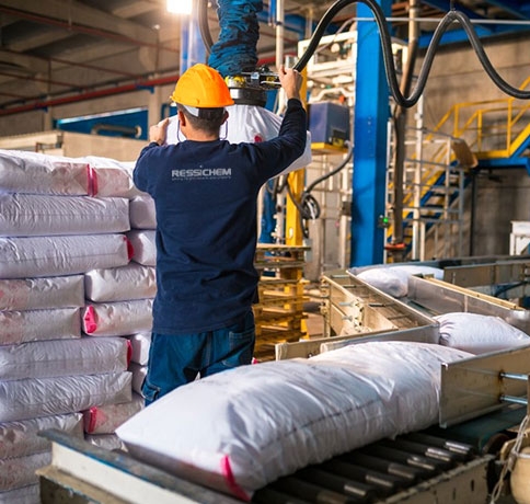 Worker in a factory with Ressichem logo on the back