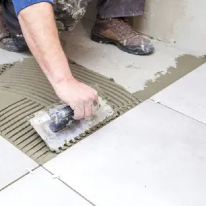 Worker applying tiling and grouting materials